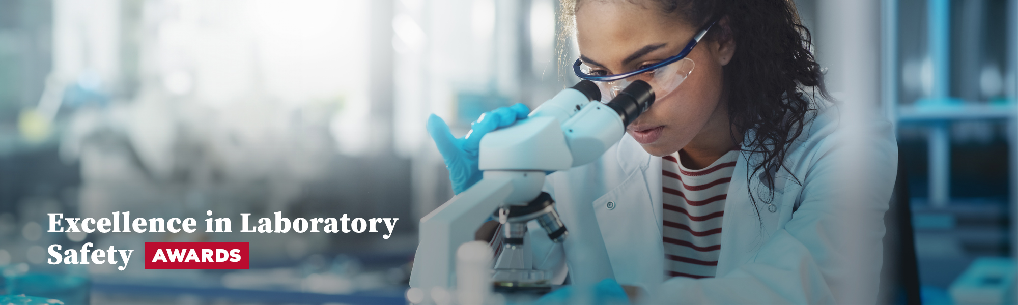 Women with safety eyewear looking into microscope