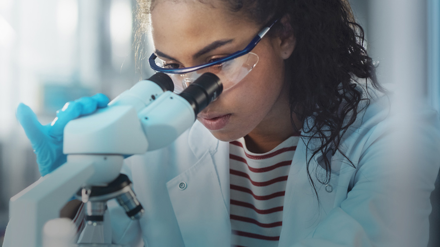 person looking through microscope