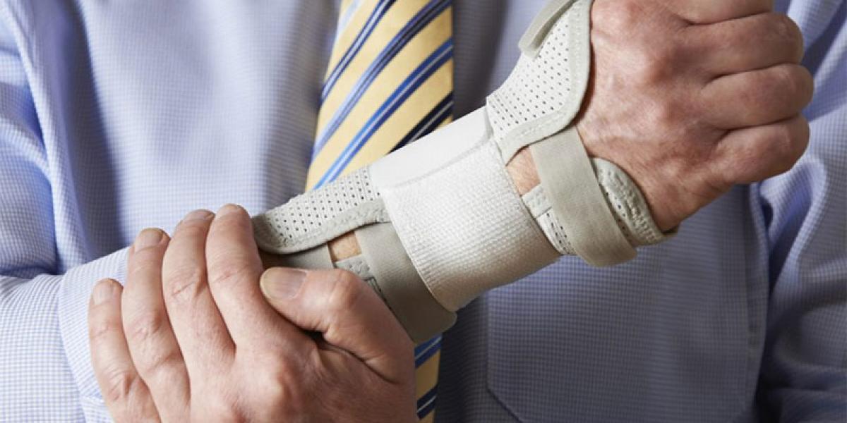 man holding his arm in a wrist brace