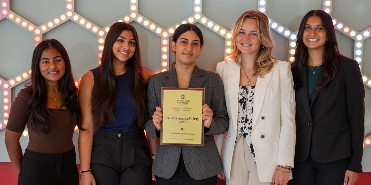 The Scarlet Consulting Group holding their award smiling for a photo.