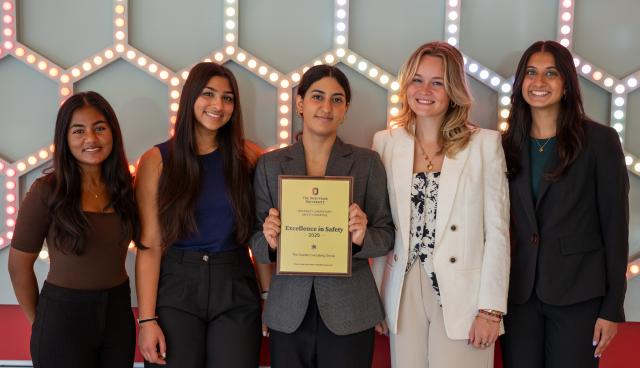 The Scarlet Consulting Group holding their award smiling for a photo.