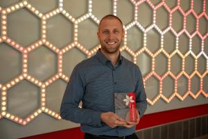 Ryan Petitti holding his award smiling for a photo.