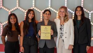 The Scarlet Consulting Group holding their award smiling for a photo.