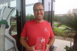 man standing outside with safety trophy